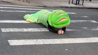 Person crawling on street floor green caterpillar