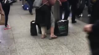 Woman in pink dances to music in subway