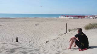 CACHORRO BRINCANDO NA AREIA DA PRAIA COM SEU DONO