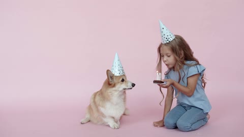 A girl and a dog wearing party hats