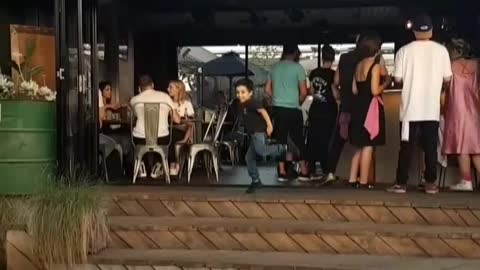 Little boy black shirt dancing by stairs