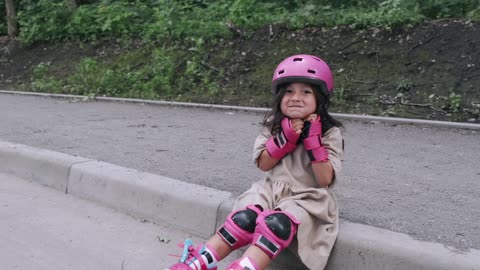 Little Girl Wearing Pink Roller Skates and Pink Safety Gear