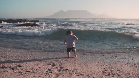 The waves of the sea pull the little boy and his mother rescues him