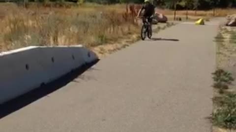 Mountain biker rides onto road divider and falls head first friend is happy