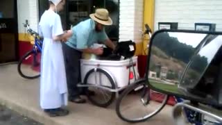Amish at McDonald's with baby in cart behind a bike