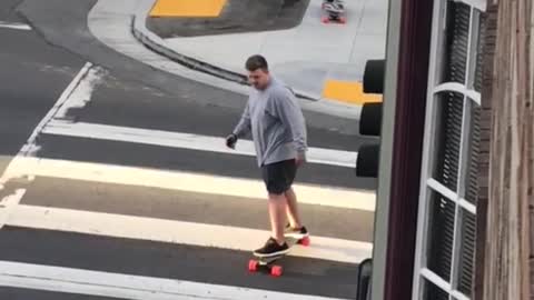 Big guy grey shirt skateboards across street crossing walk