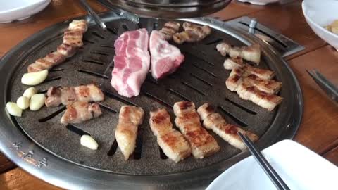 The sound of grilling pork belly with garlic in Korean food.