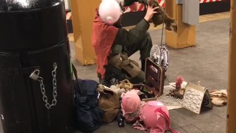 Scary singing subway guy with animal in pink costume and pink balloon tied to head