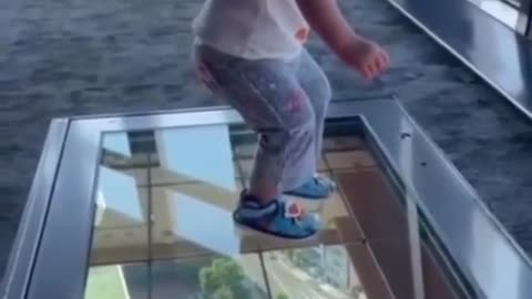 A boy stands on glass floor. And his funny reaction. When he saw how high the building was 😂😅