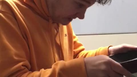 Man in orange sweater knocks head on pan