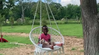 Little Boy Enjoys Hammock Swing With His Puppy