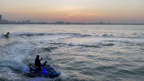 See high-speed jet-ski sprint with water mist in Doha, Qatar at sunset