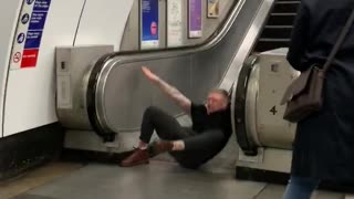 Drunk guy slides down in between escalators and falls down, gets back up and is okay