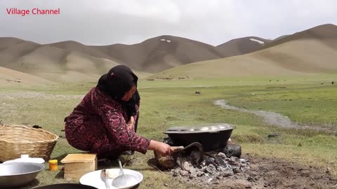 "Shepherd Mother Cooking in the Afghan Wilderness: A Glimpse into Traditional Life"