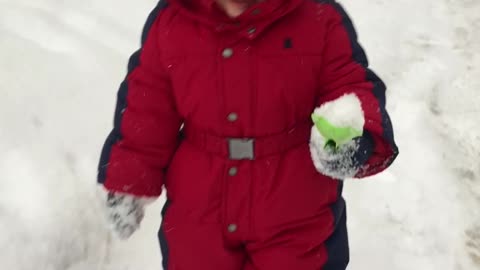 A small child walks in the snow in winter
