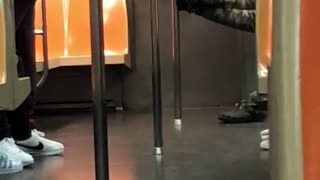 Laying feet against pole on subway train