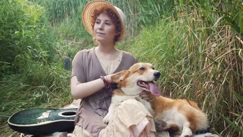 Happy corgi dog with the owner girl in the park near the reed