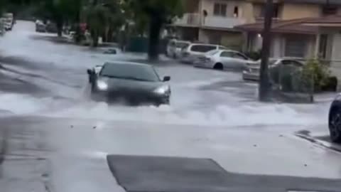 Cars drive across stagnant water roads.