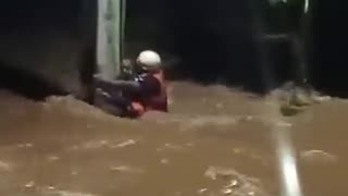 Vídeo mostra equipe de resgate se agarrando a poste de luz em meio à correnteza