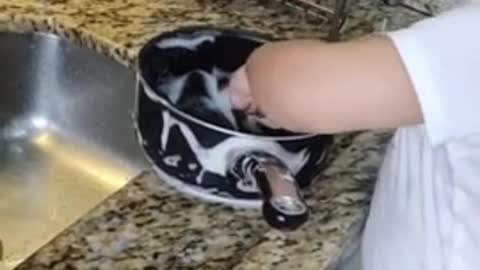 Helpful baby assists mom with the dishes