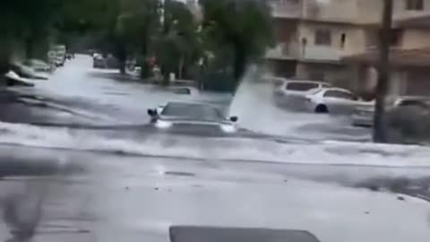 Car driving across waterlogged road