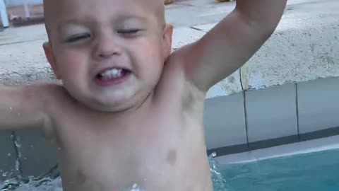 Funny baby is diving in pool