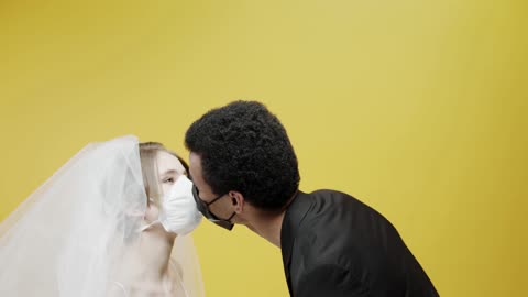 runble/A Newly Wed Couple Kissing While Wearing Face Masks