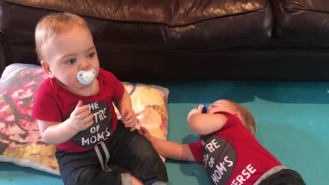 Funny twin infant boys battle it out for pacifier