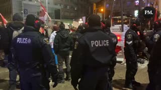 Several police officers are making their way through the dance party at Parliament Hill