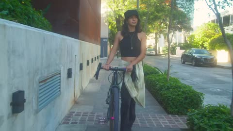 Young woman walking with her bicycle