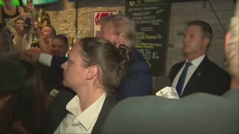 Donald Trump gets swarmed as he hands out pizza at Iowa pub