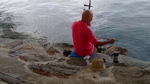 Man playing erhu by the lake at the Old Summer Palace, Beijing