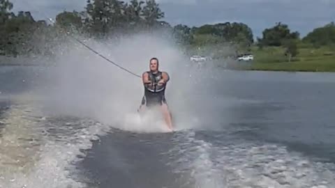 Water skiier raises fist in air and it causes him to faceplant