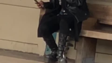 Guy with boots with mohawk waiting for train at train station