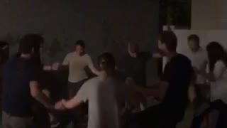 Friends dance in circle outside at night