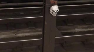 Skull tied to pillar in subway tracks