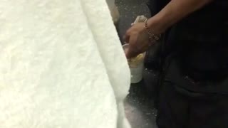 Man prepares meal on subway train floor