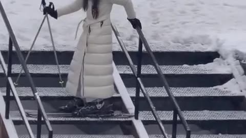 Woman Descends Stairs in Skis