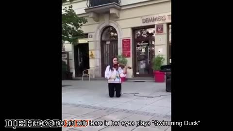 A violinist girl with tears in her eyes plays Plywe kacha in the center of Warsaw