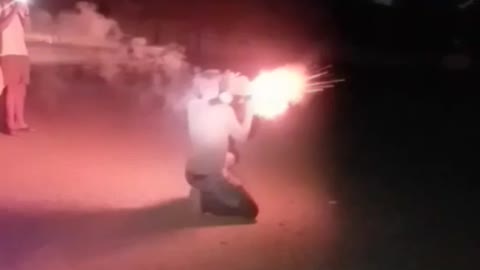 Guy green shirt launches red firework into street