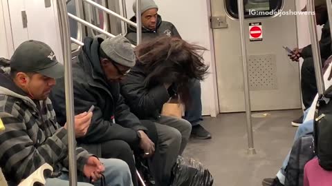 Woman puts on weave on subway train, man helps her