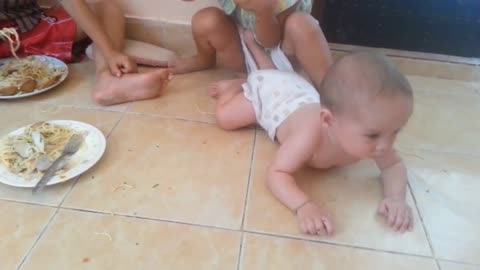 Baby hungerly attacks his sisters spaghetti