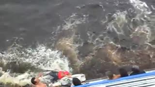 Man Hangs from Boat