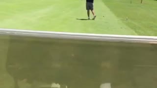 White hat unsuspecting golfer hit by golf cart after swing