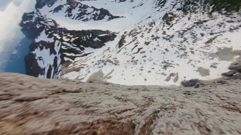 Drone footage of a snowy mountain landscape.