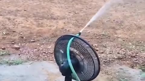 Watering the garden with a hose and a fan