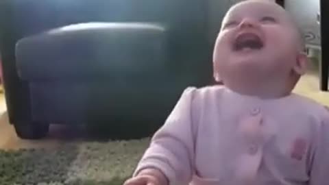 Cute baby playing with dog and laughing