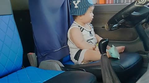 Cute baby as truck driver