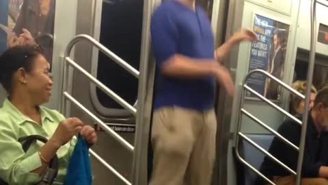 Guy blue shirt glasses red headphones dancing subway train