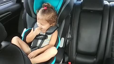 Little girl in blue car seat dancing to taylor swift